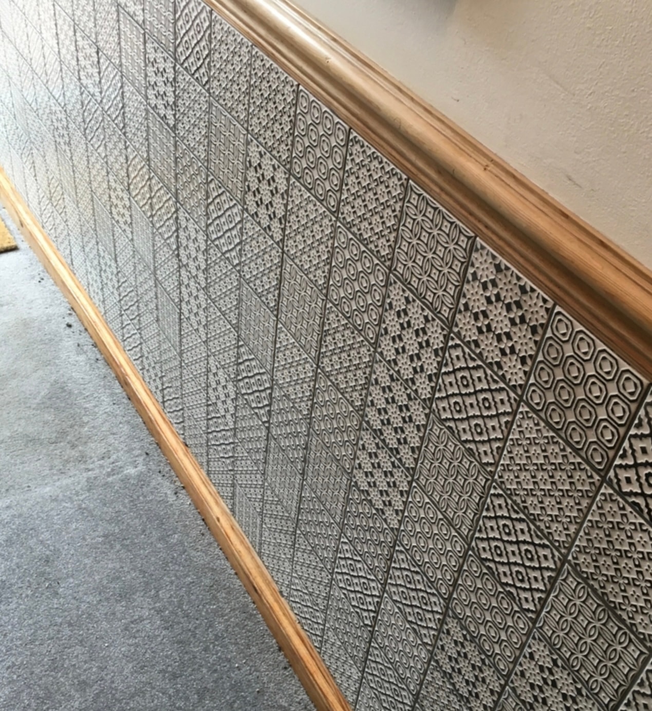 Decorative patterned wall tiling along the entrance hallway of a Victorian home, finished beneath the timber dado rail.